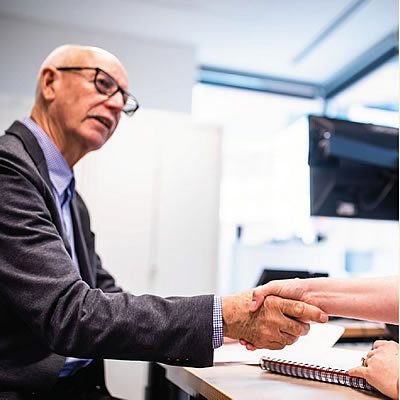 A man at a desk shaking hands